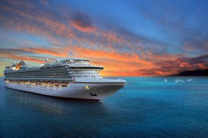 Luxury cruise ship sailing as you enjoy a beautiful sunrise.