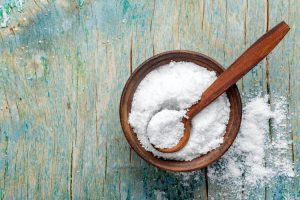 Wooden bowl and spoon with fine salt.