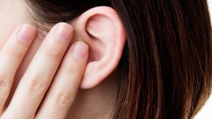 Person applying pressure on ear.