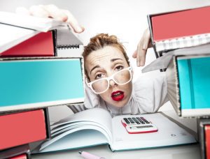 Woman stress with and overload of work on her desk.