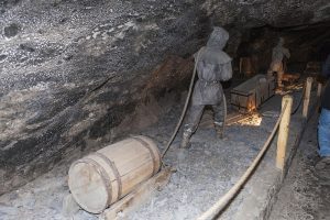 Two man hauling equipment into a salt mine.