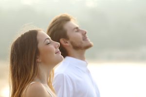 Two smiling people breathe in fresh air